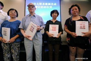 Yu Changxiang(2th L), victim and survivor of Nanjing Massacre, and his three daughters receive data sets about the massacre during the launching ceremony of a project to register victims of Nanjing Massacre, in Nanjing, capital of east China's Jiangsu Province, July 6, 2014. The Memorial Hall of the Victims in Nanjing Massacre by Japanese Invaders officially began to register the victims in massacre on Sunday.